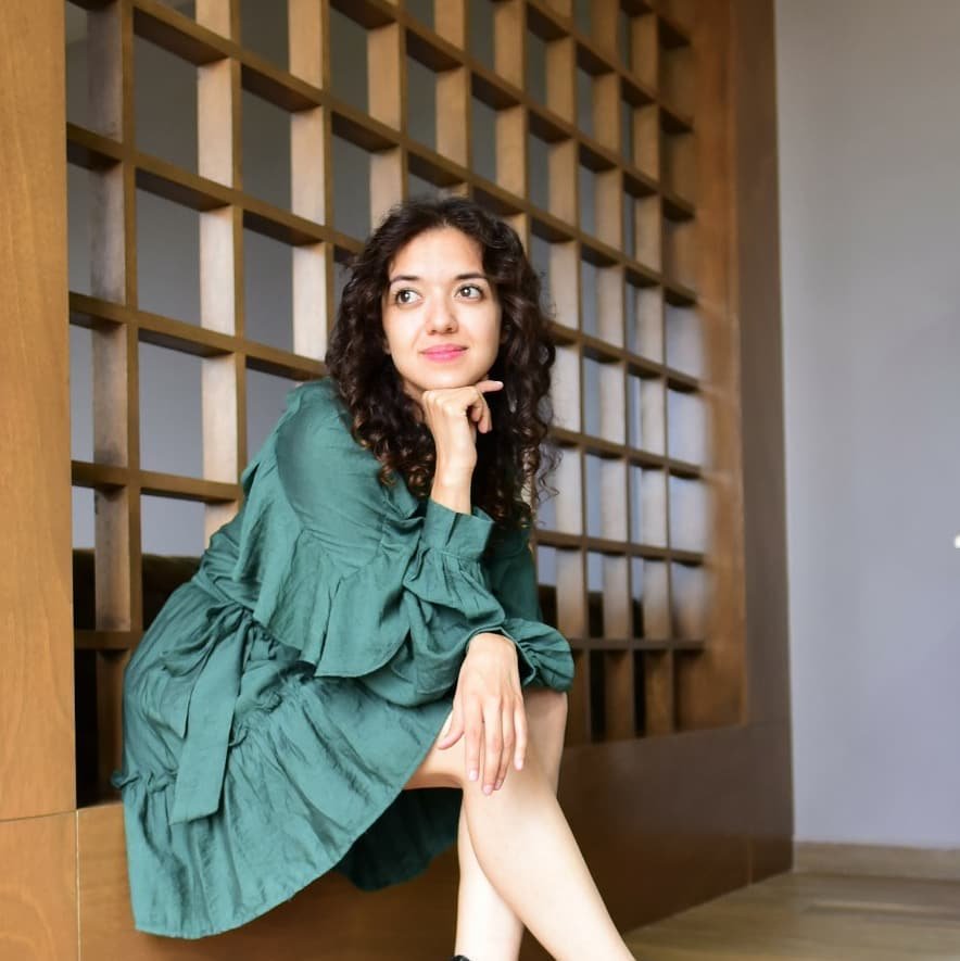 Mujer sentada con un vestido verde esmeralda