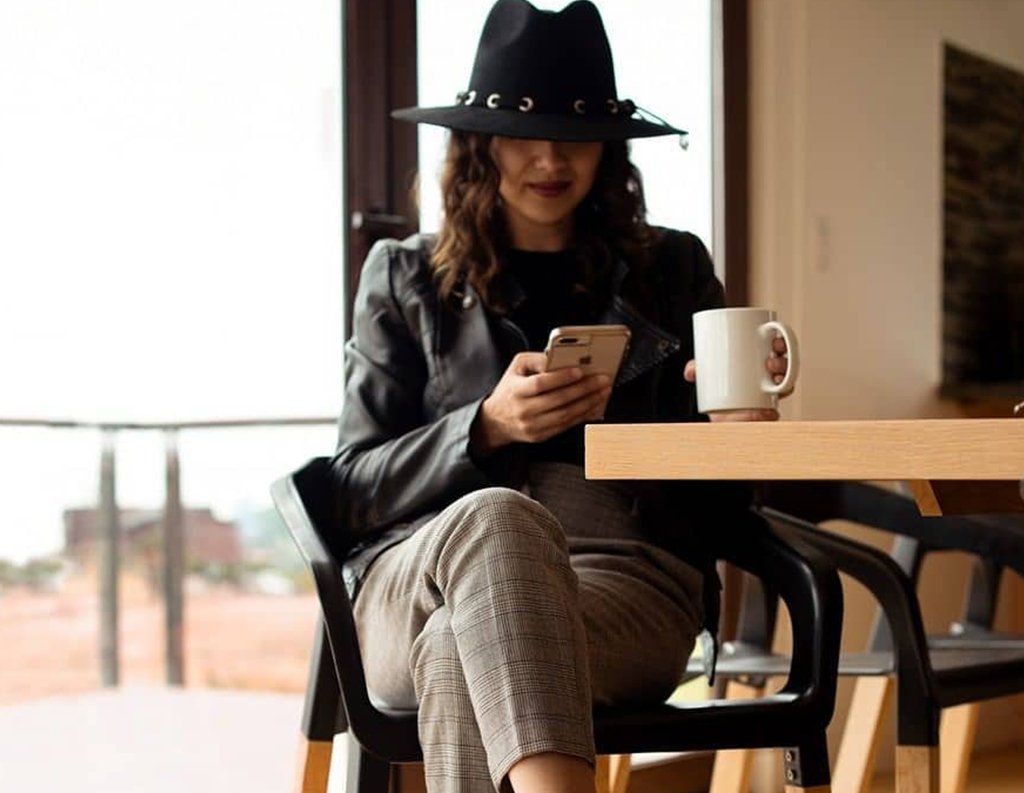 persona sentada con una taza de cafe mientras trabaja